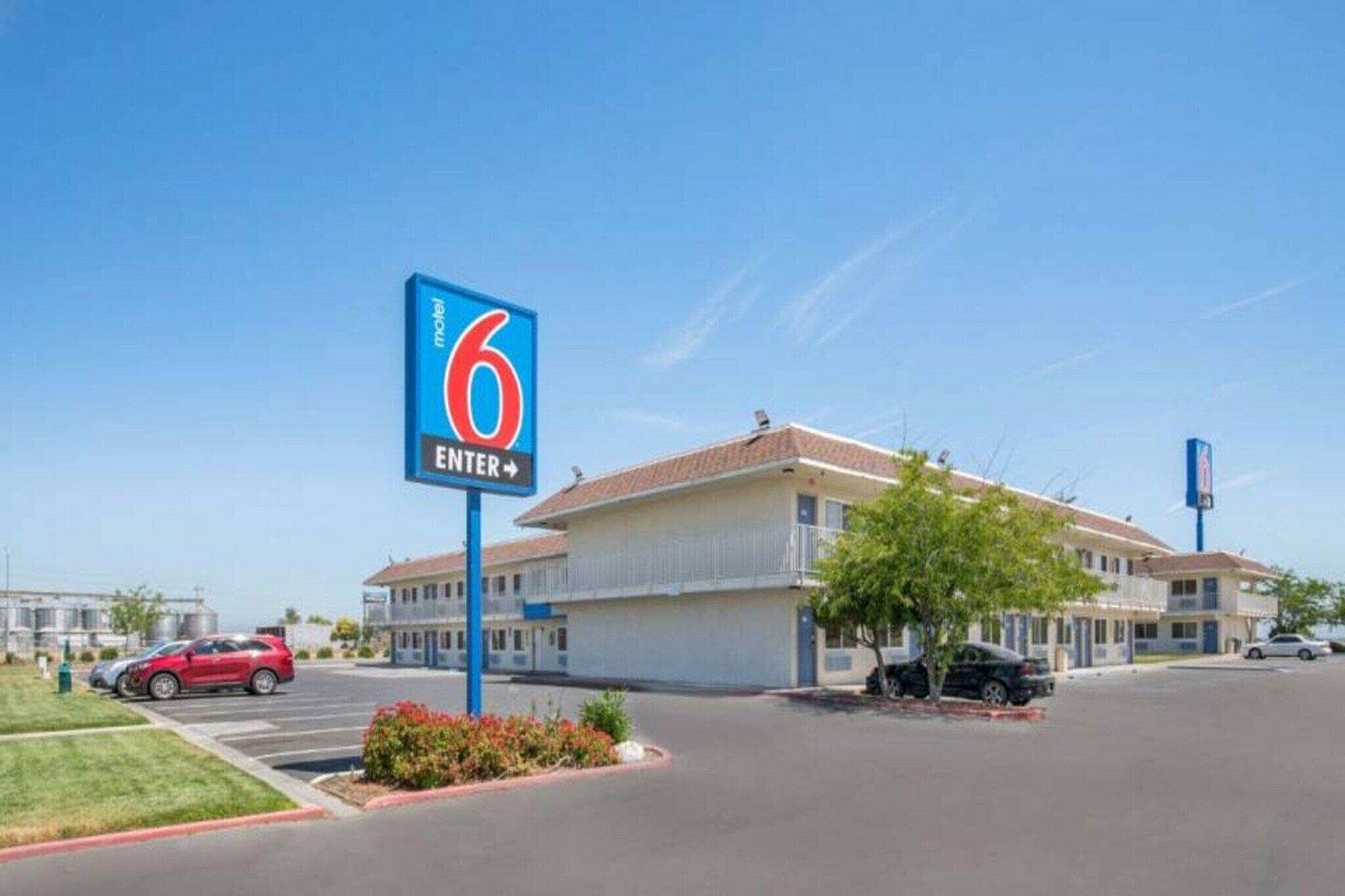 A motel with a large blue sign indicating the number 6 and an arrow pointing right.