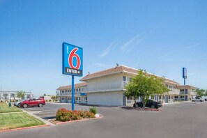 A motel with a large blue sign indicating the number 6 and an arrow pointing right.