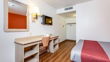 Ein Hotelzimmer mit Bett, Schreibtisch, Stuhl und Fernseher.