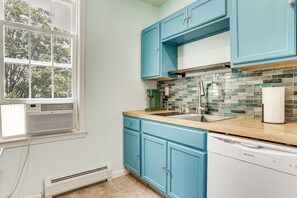A kitchen with blue cabinets, a stainless steel sink, and a tiled backsplash. - Walk to HBLR & Liberty State Park: Jersey City Apt (Jersey City)