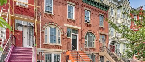 A red brick building with a pink staircase and a beige staircase.