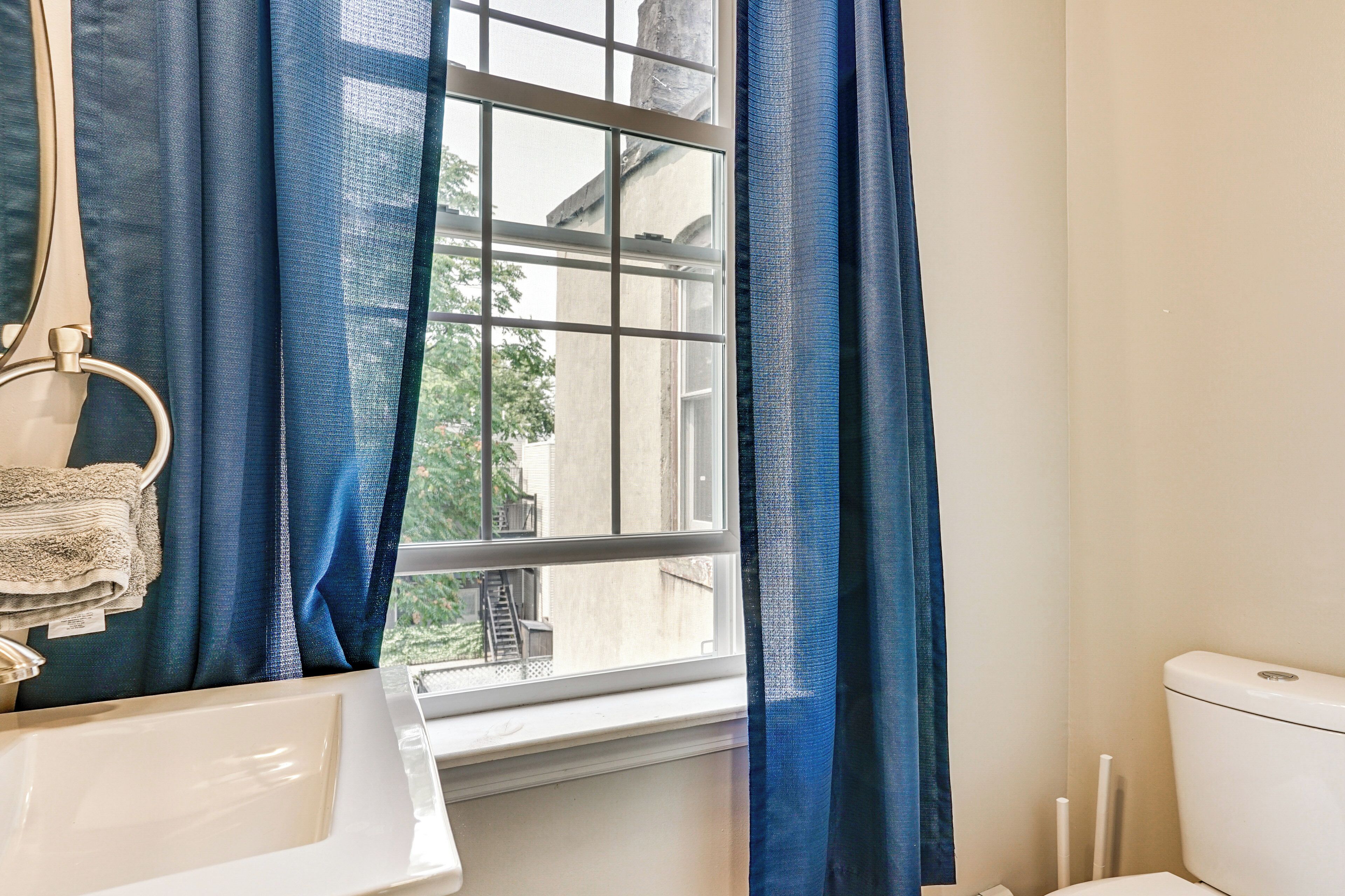 A bathroom with a window, a sink, and a toilet.