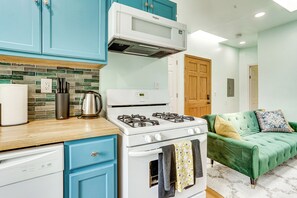 A compact kitchen with a stove, microwave, and a coffee maker on the counter. - Walk to HBLR & Liberty State Park: Jersey City Apt (Jersey City)