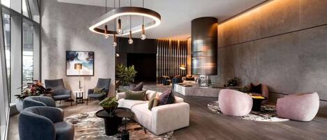 A modern interior with a seating area, a round rug, and a large window.