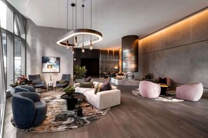 A modern interior with a seating area, a round rug, and a large window. - Sky-high pool & sauna, near Marvel (Melbourne)