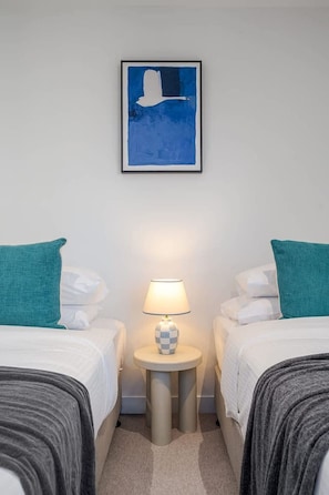 A hotel room with two beds, a nightstand with a lamp, and a framed artwork on the wall. - Sky-high pool & sauna, near Marvel (Melbourne)