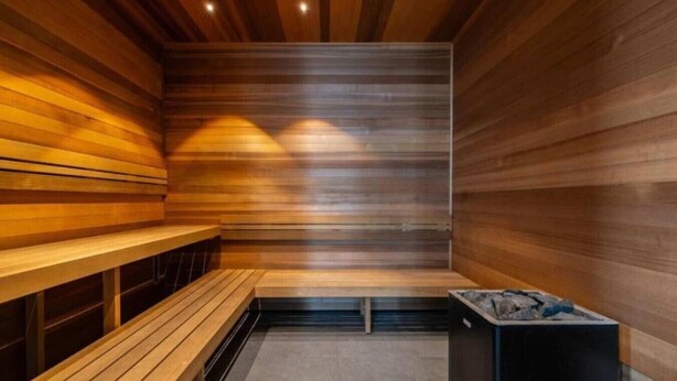 Eine Sauna mit Holzbänken und einer Steinwanne.