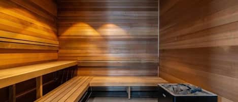 A sauna with wooden benches and a stone basin.