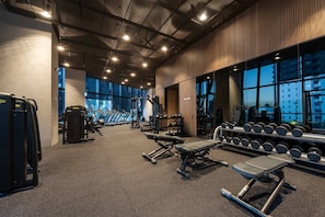 A gym with treadmills, weight machines, and dumbbells. - Sky-high pool & sauna, near Marvel (Melbourne)