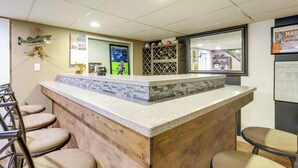 A bar area with a counter, seating, and a display of sports memorabilia. - Hot Tub, Gym & Office! Family Home in Massillon (Massillon)