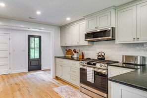 A kitchen with white cabinets, a stainless steel range, and a microwave. - Modern Farmhouse Between Mount Snow & Stratton! (Wardsboro)