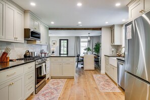 A modern kitchen with stainless steel appliances, wooden flooring, and a central island. - Modern Farmhouse Between Mount Snow & Stratton! (Wardsboro)