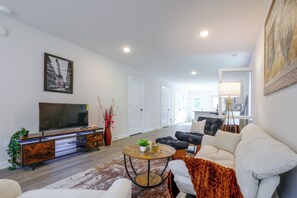 A modern living room with a flat-screen TV, a coffee table, and a sofa. - Hickory Townhome w/ Balcony: 2 Mi to Downtown (Hickory)