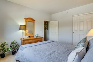 A bedroom with a bed, dresser, mirror, and two doors. - Pool & Hot Tub Access! Family Condo in Oro Valley (Oro Valley)