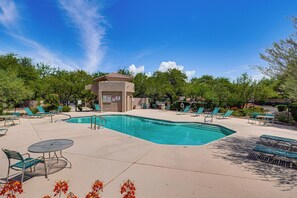 A pool area with lounge chairs, a small building, and surrounding trees. - Pool & Hot Tub Access! Family Condo in Oro Valley (Oro Valley)