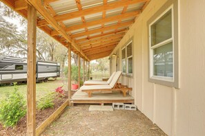 A covered porch with a wooden bench and a small garden area. - 5-Unit Retreat Near World Equestrian Center & HITS (Morriston)