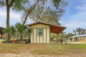 A small, single-story building with a green and beige exterior, a covered porch, and a small window. - 5-Unit Retreat Near World Equestrian Center & HITS (Morriston)