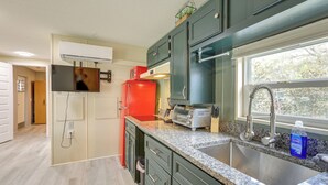 A modern kitchen with green cabinets, a red refrigerator, a built-in oven, and a window with a view of trees. - 5-Unit Retreat Near World Equestrian Center & HITS (Morriston)