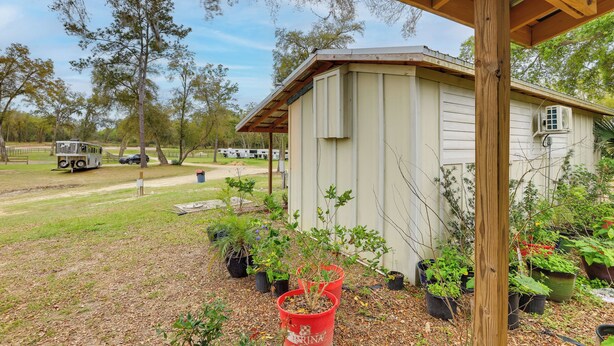 A small shed with a wooden roof, surrounded by potted plants and a grassy area. - 5-Unit Retreat Near World Equestrian Center & HITS (Morriston)