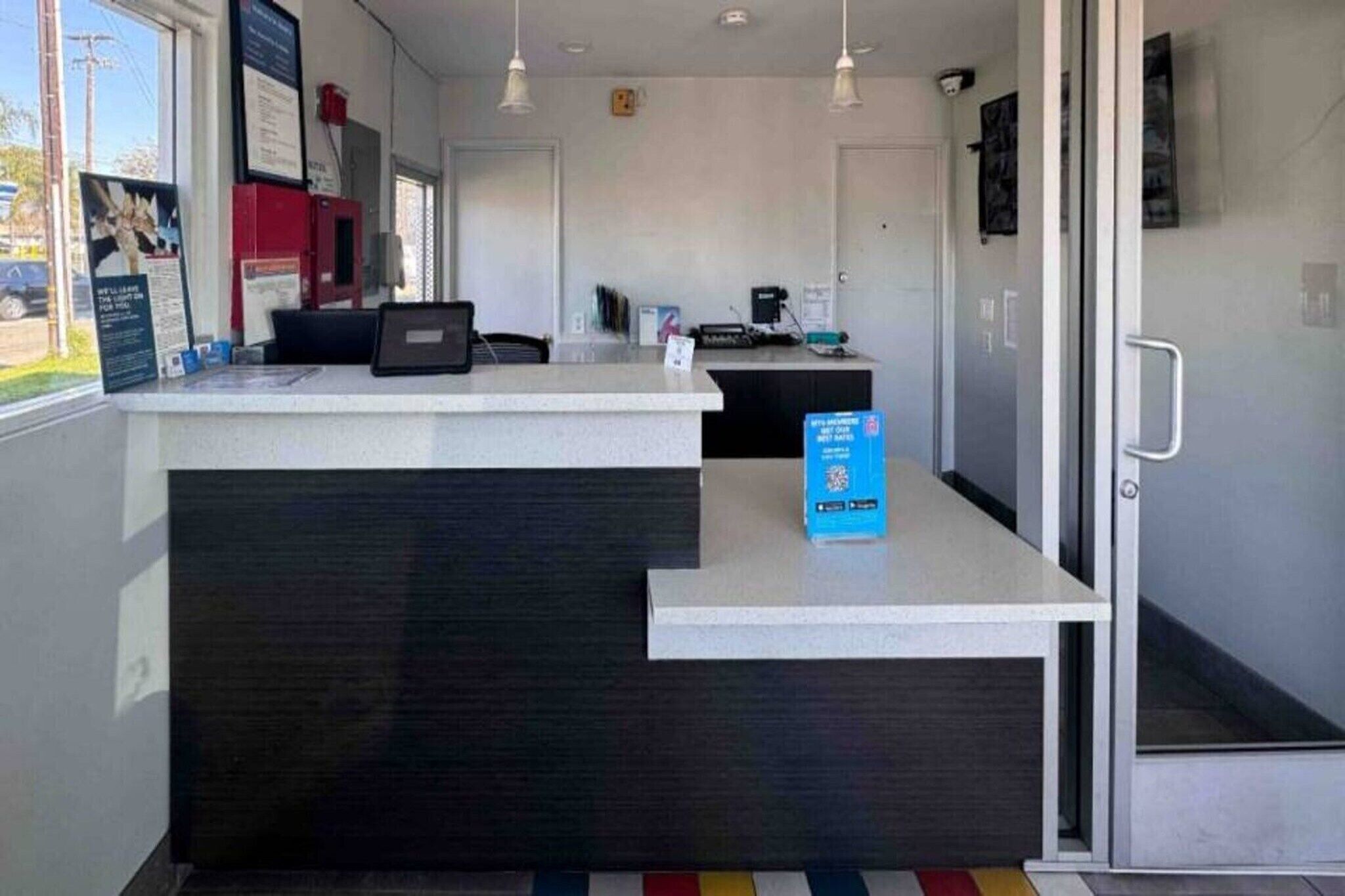 A reception area with a counter, a computer, and a blue informational box.