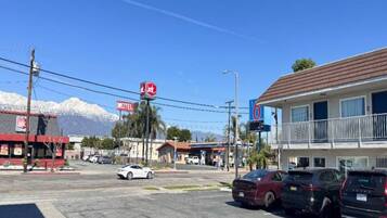 A motel with a red sign, a gas station, and a mountain in the background.