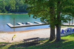 Un parc au bord du lac, équipé d’un quai, d’une table de pique-nique et de chaises.