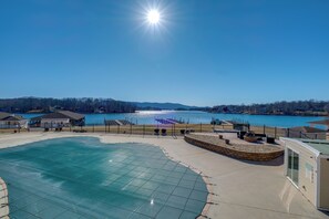 A swimming pool with a glass enclosure, a waterfront view, and a small building with a sign. - Waterfront Condo w/ Cove View on Smith Mtn Lake (Huddleston)