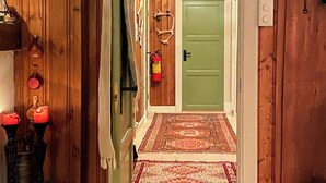A wooden interior with a green door, a fire extinguisher, and a patterned rug. - Secluded cabin with views of Raulandsfjell (Rauland)