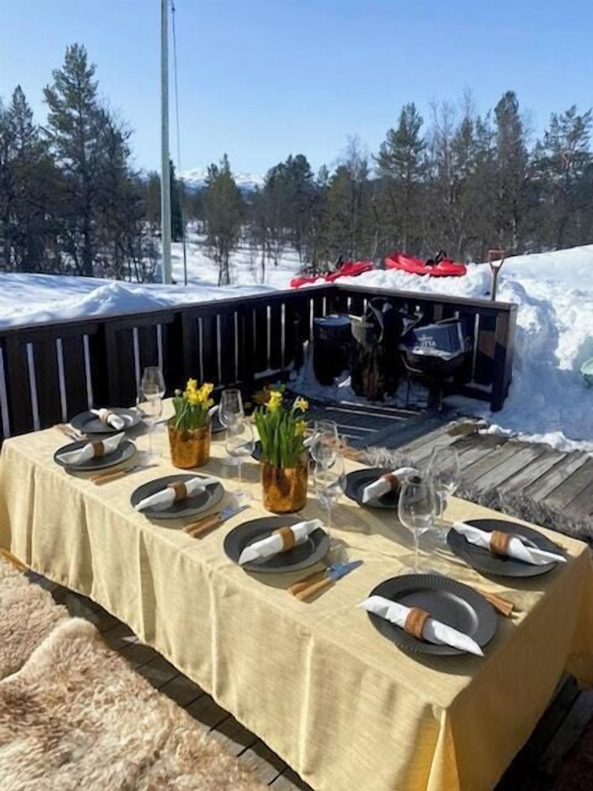 Mesa para cuatro personas al aire libre, rodeada de nieve.