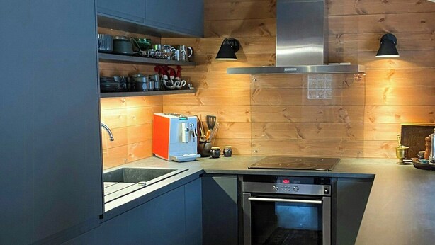 A compact kitchen with modern appliances, wooden accents, and a patterned rug. - Secluded cabin with views of Raulandsfjell (Rauland)