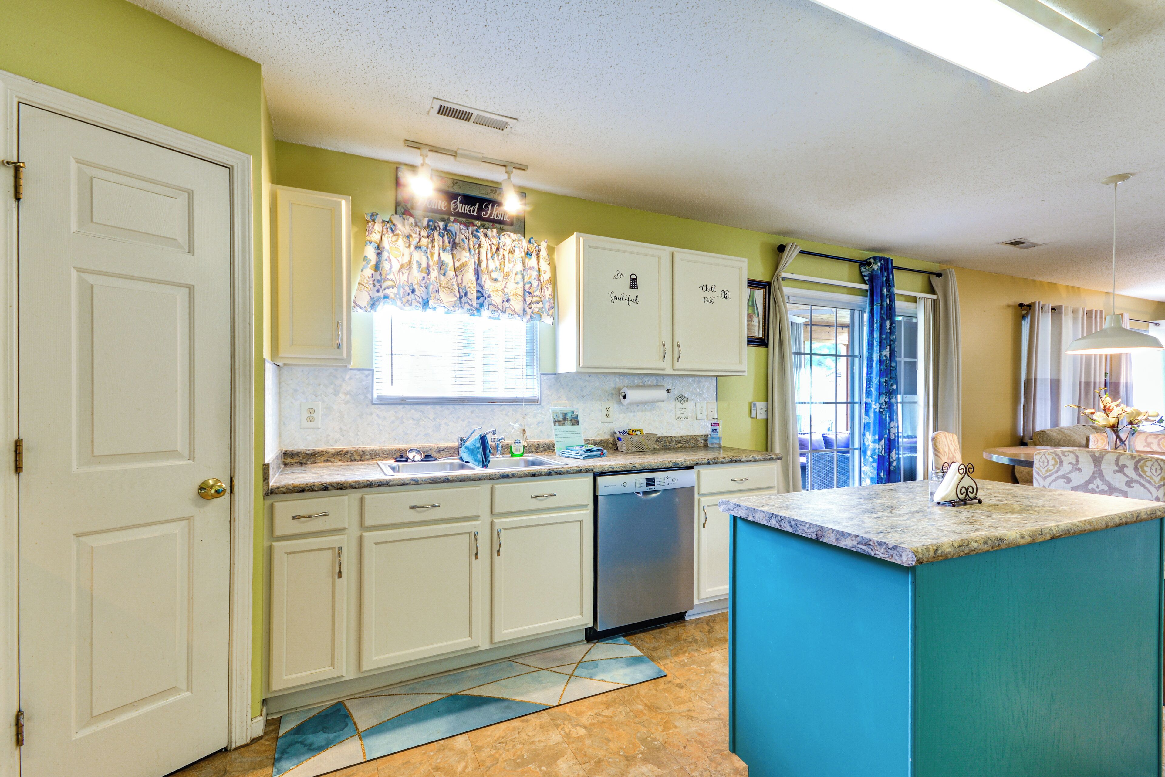 A kitchen with white cabinets, a dishwasher, and a blue accent wall.