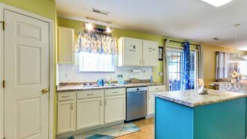 A kitchen with white cabinets, a dishwasher, and a blue accent wall.