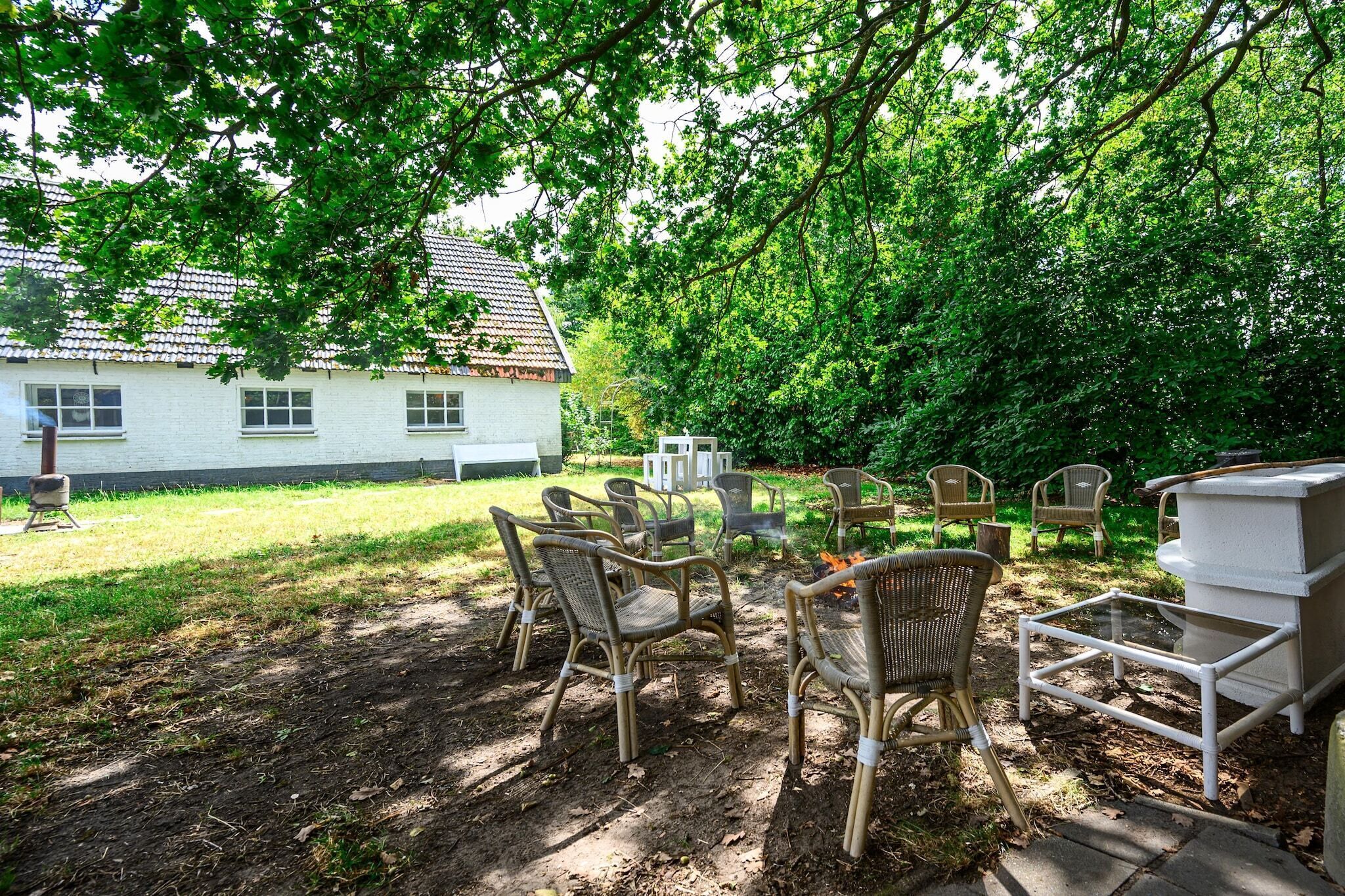 Un jardin avec des meubles d’extérieur, un barbecue et une maison en arrière-plan.