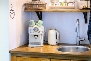 A kitchen with a toaster, a kettle, and a sink.