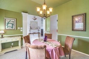 A dining room with a chandelier, a table set for four, and a floral wall decoration. - Spacious Backyard & Patio! Family Haven in Odessa (Odessa)