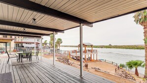 A wooden deck with outdoor furniture, overlooking a body of water and a distant landscape. - Colorado River Family Escape in Bullhead City (Bullhead City)