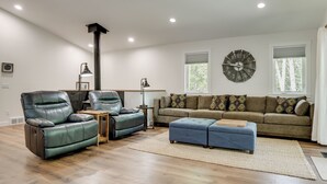 A modern living room with leather chairs, a sofa, a clock, and a fireplace. - Newly Built Wooded Getaway in Grand Junction (Grand Junction)