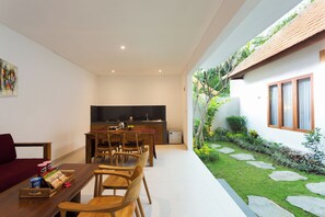 Una cocina moderna con comedor, un refrigerador pequeño y una cafetera.