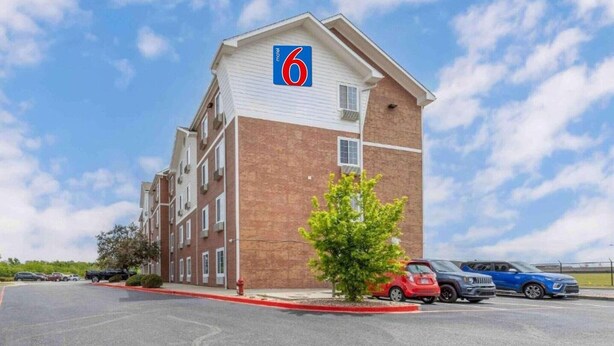 A motel with a '6' sign, a parking lot, and a clear sky. - 2 Full Beds | Non-Smoking, Micfridge (Norman)