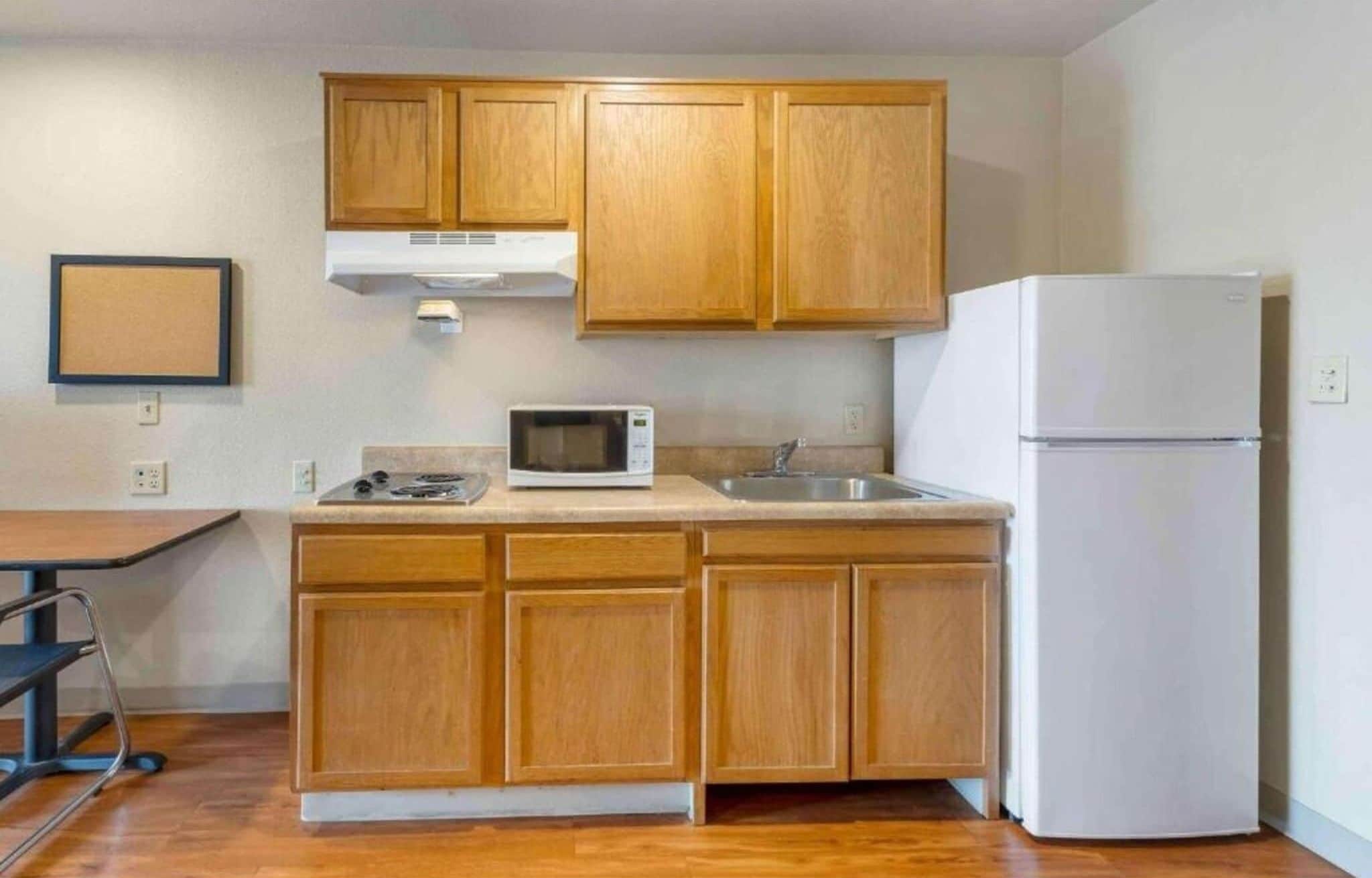 A kitchen with wooden cabinets, a microwave, a stove, and a refrigerator.