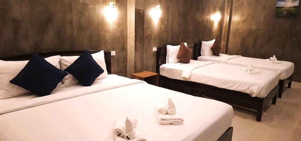 Habitación de hotel con dos camas, cada una con almohadas y toallas.