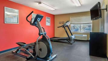 A gym with treadmills, an elliptical, and a weight bench.