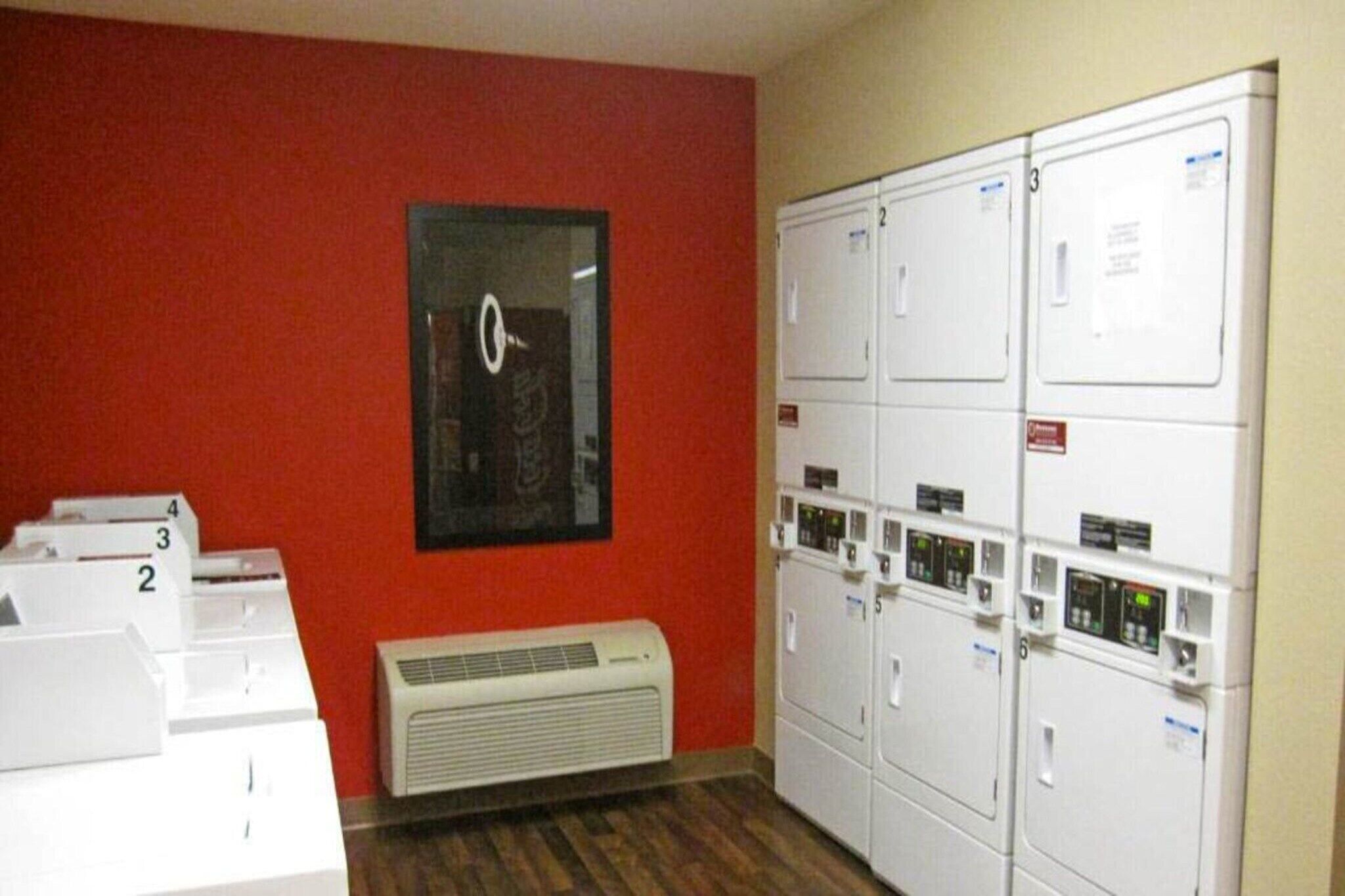 Une buanderie équipée d’une pile de sèche-linge, d’une horloge murale et d’une unité de ventilation.