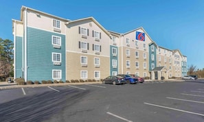 A multi-story hotel with a parking lot and several cars parked. - 1 Queen Bed | Non-Smoking, Kitchen (Little Rock AR)