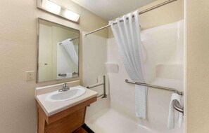 Un baño con lavabo, espejo y ducha.