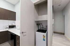 Eine kleine Küche mit Kühlschrank, Mikrowelle und Kaffeemaschine.