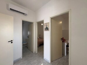 A hallway with two open doors leading to a bedroom and a bathroom. - Villa in Santa Maria Del Focallo with 3 bedrooms sleeps 6 (Santa Maria Del Focallo)