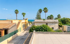 A residential area with a clear view of the sea, palm trees, and a tiled roof. - Villa in Santa Maria Del Focallo with 3 bedrooms sleeps 6 (Santa Maria Del Focallo)