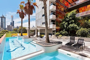 A rooftop swimming pool with lounge chairs and a cityscape view. - Exclusive 1-room apartment in an elevated location, just steps away from shops. (Southbank)
