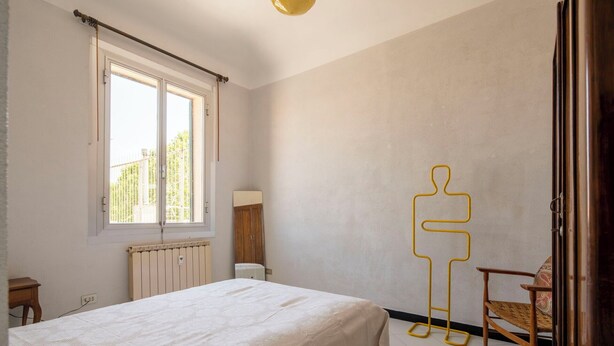 A bedroom with a bed, a radiator, a window, and a chair. - La Terrazza in Centro, Genova (Genoa)